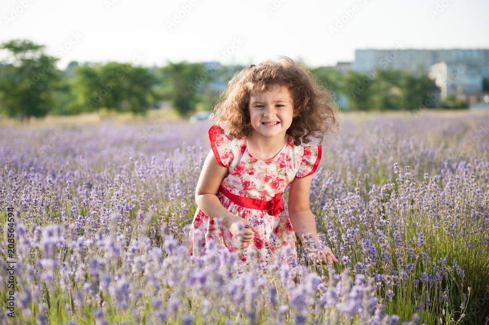 funny beautiful little girl with clenched teeth bouquet of flowers in field