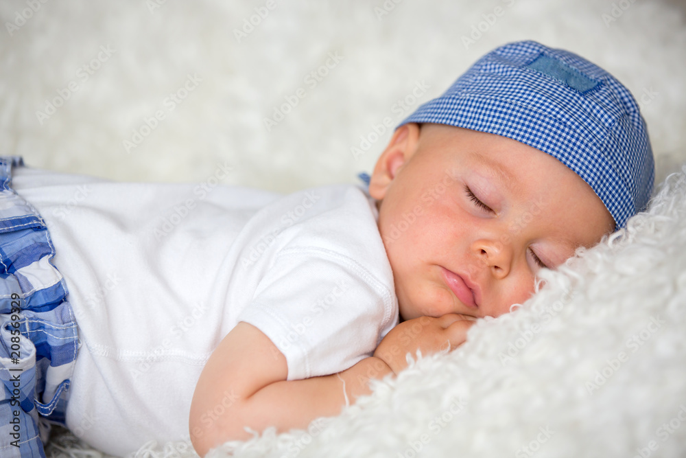 Cute baby boy, sleeping in bed with hat Cute baby boy, sleeping in bed with hat