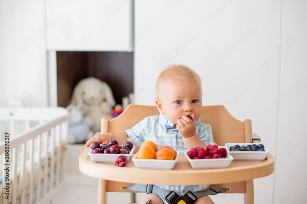Adorable little baby boy, eating fresh fruits at home Adorable little baby boy, eating fresh fruits at home