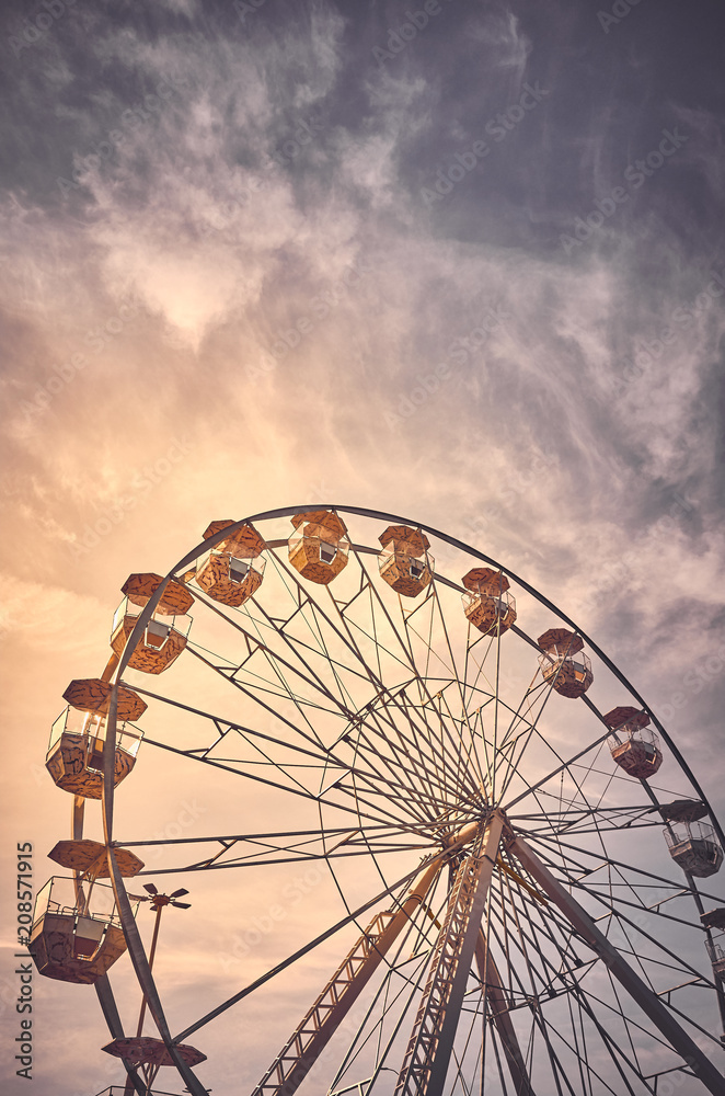 Vintage toned picture of a Ferris wheel at sunrise.