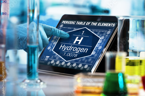 scientist consulting on the digital tablet data of the chemical element Hydrogen H / researcher working on the computer with the periodic table of elements