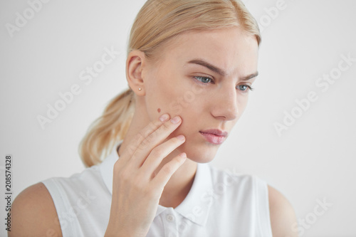 Skin problems. Girl looking in the mirror