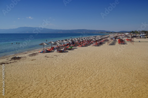 Syunny beach with umbrellas and a clean blue sea photo