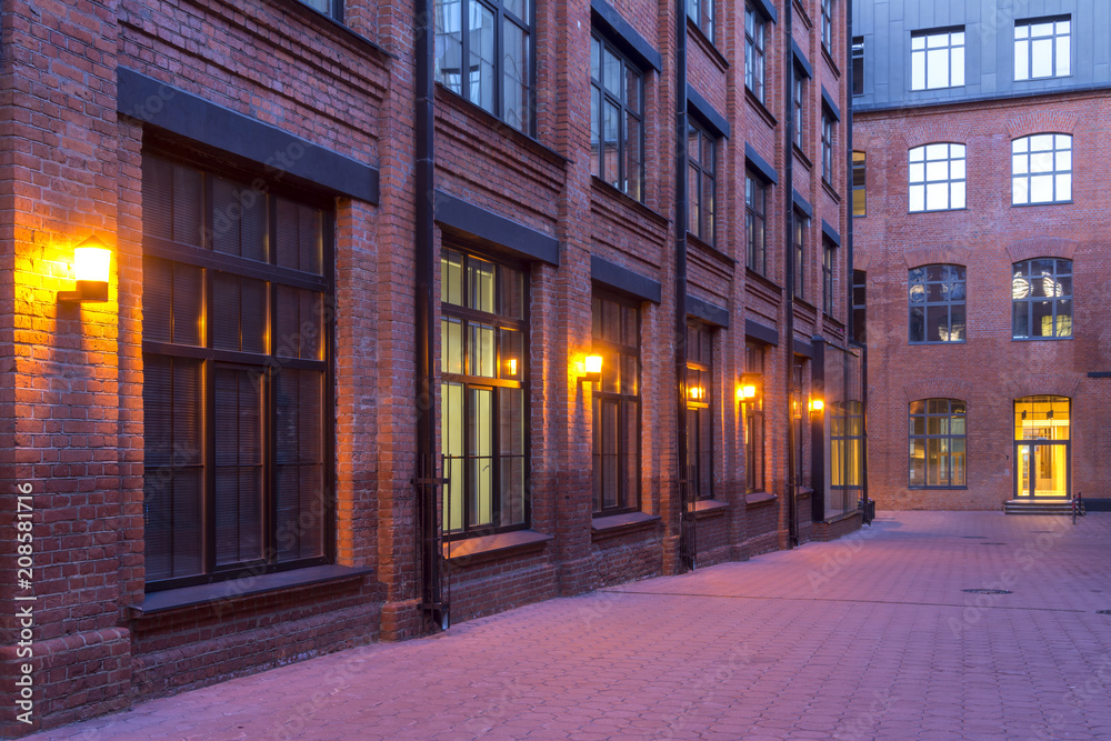 Night view. Industrial building. Modern Loft-style offices located in the old factory building. Red brick houses. Vintage. Buildings with large Windows. Vintage
