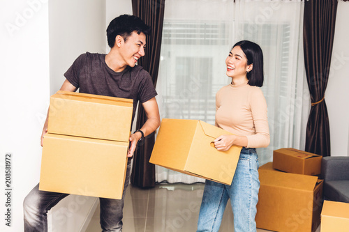 Vászonkép Happy young couple carrying boxes and moving into their new home