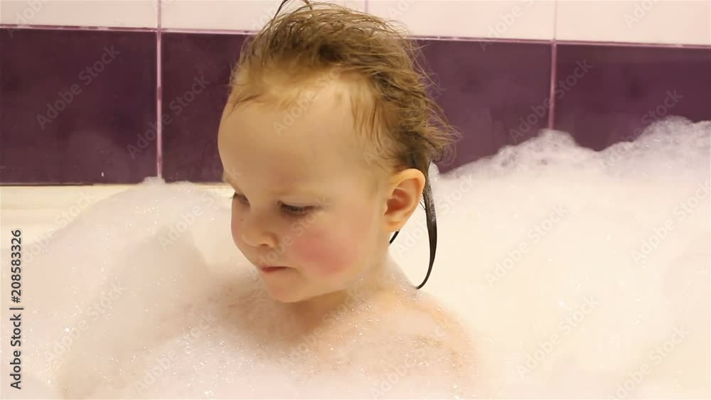 little happy girl bathes in the bathroom with foam. He plays with foam. little happy girl bathes in the bathroom with foam. He plays with foam.