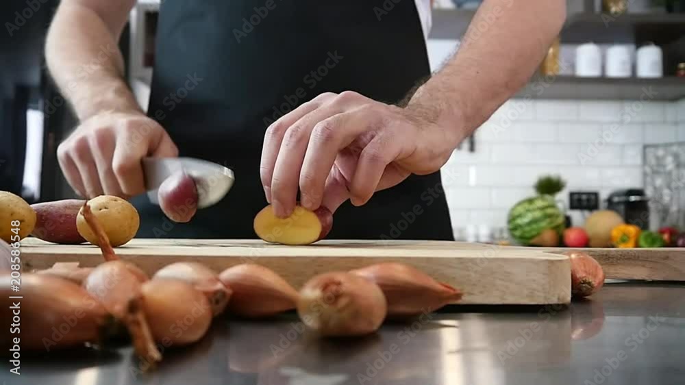 Cook Cutting Potatoes in kitchen Cook Cutting Potatoes in kitchen