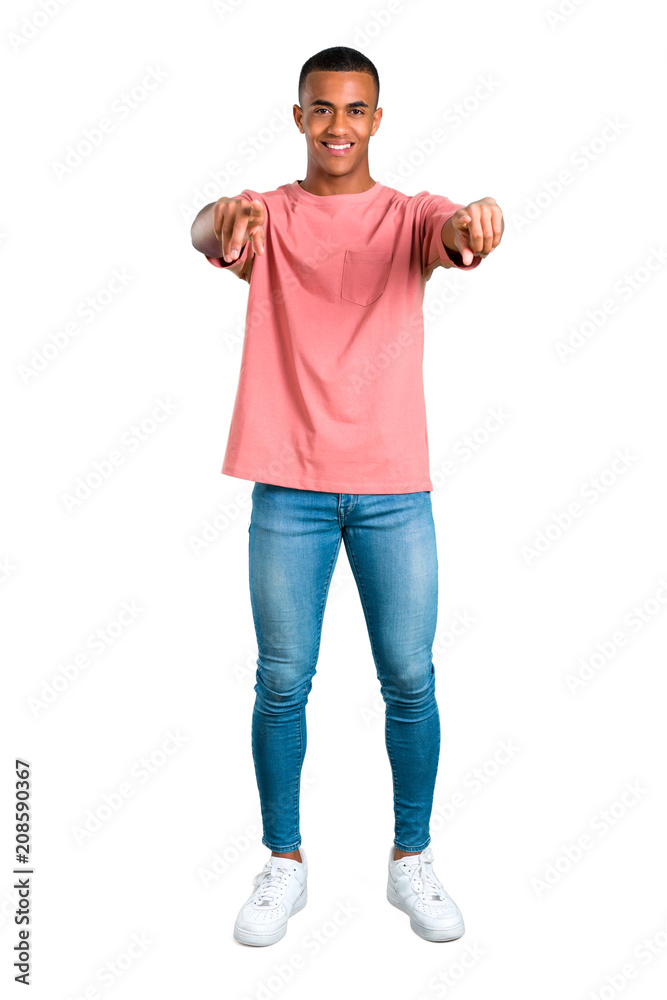 Standing young african american man points finger at you with a confident expression on isolated white background Standing young african american man points finger at you with a confident expression on isolated white background