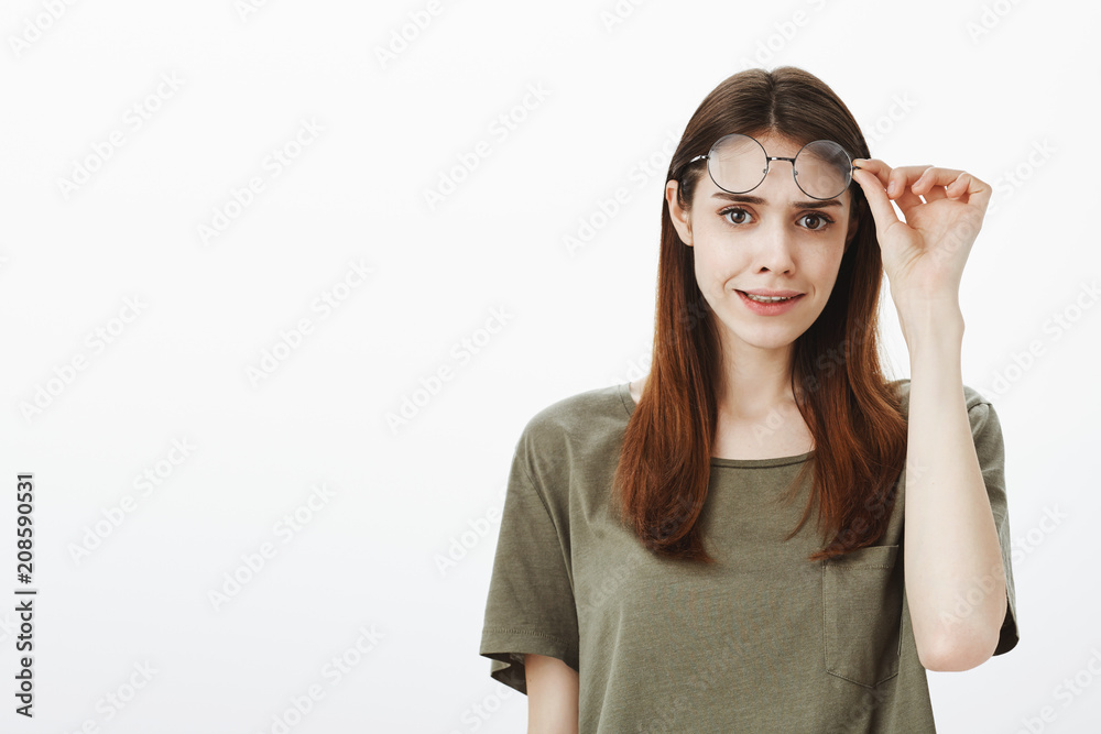 Girl looking with disbelief, having hesitations and trust issues. Portrait of frustrated caucasian female student with brown hair, taking off trendy glasses and looking with doubt at camera Girl looking with disbelief, having hesitations and trust issues. Portrait of frustrated caucasian female student with brown hair, taking off trendy glasses and looking with doubt at camera