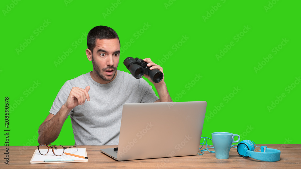 Concept of a young man worried about his security on his laptop - Green background Concept of a young man worried about his security on his laptop - Green background