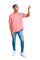 Standing young african american man touching on transparent screen on isolated white background