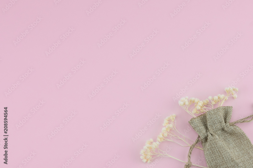 Sackcloth bag with white dried flowers on pastel pink background with copy space Sackcloth bag with white dried flowers on pastel pink background with copy space