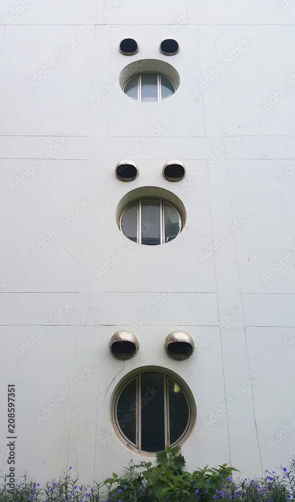 Three glass circle windows on white wall building