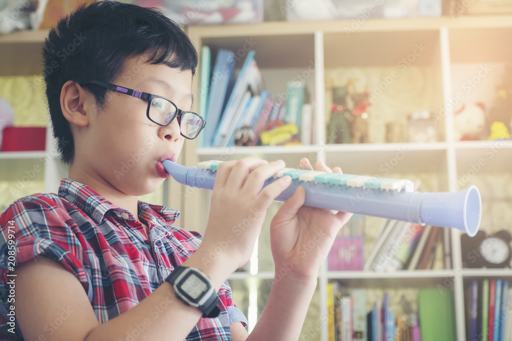 Boy playing the clarinet, trumpet at home, blowing a sweet flute,  musicology background, music skills learning and education. Stock Photo |  Adobe Stock