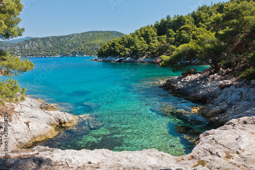 Small lagoon with pine trees and rocks over crystal clear turquoise water near Cape Amarandos at Skopelos island, Greece