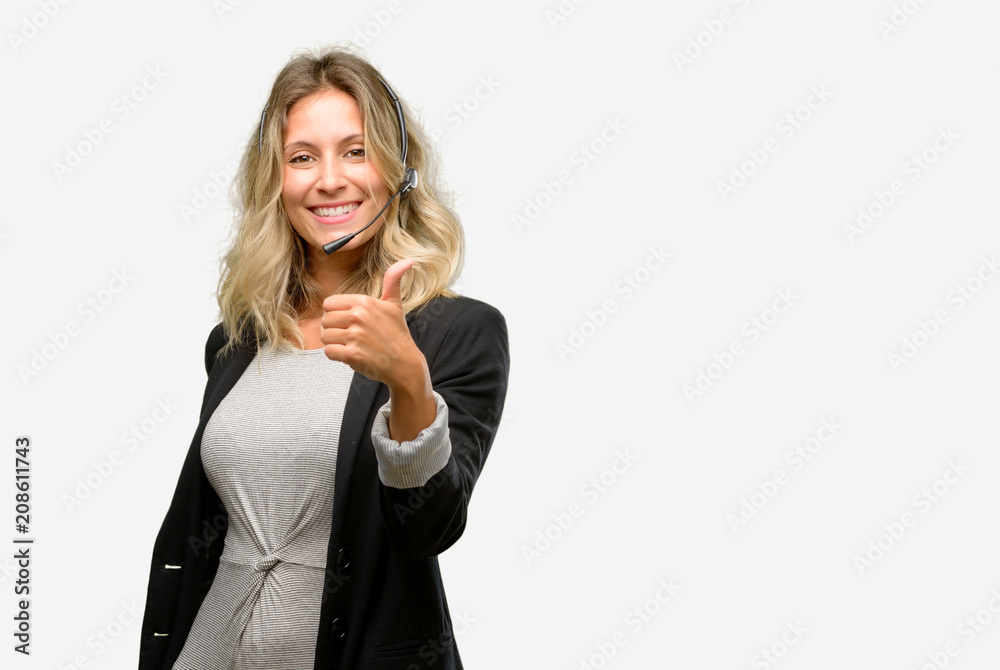 Young woman operator from call center smiling broadly showing thumbs up gesture to camera, expression of like and approval Young woman operator from call center smiling broadly showing thumbs up gesture to camera, expression of like and approval