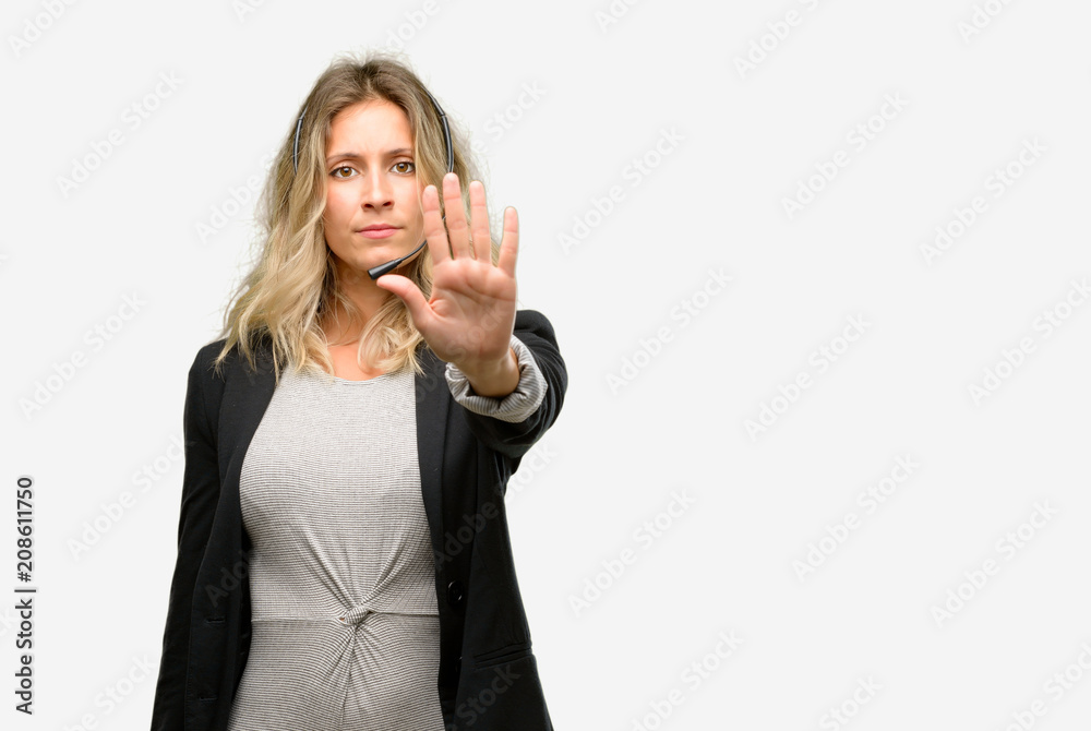 Young woman operator from call center annoyed with bad attitude making stop sign with hand, saying no, expressing security, defense or restriction, maybe pushing Young woman operator from call center annoyed with bad attitude making stop sign with hand, saying no, expressing security, defense or restriction, maybe pushing