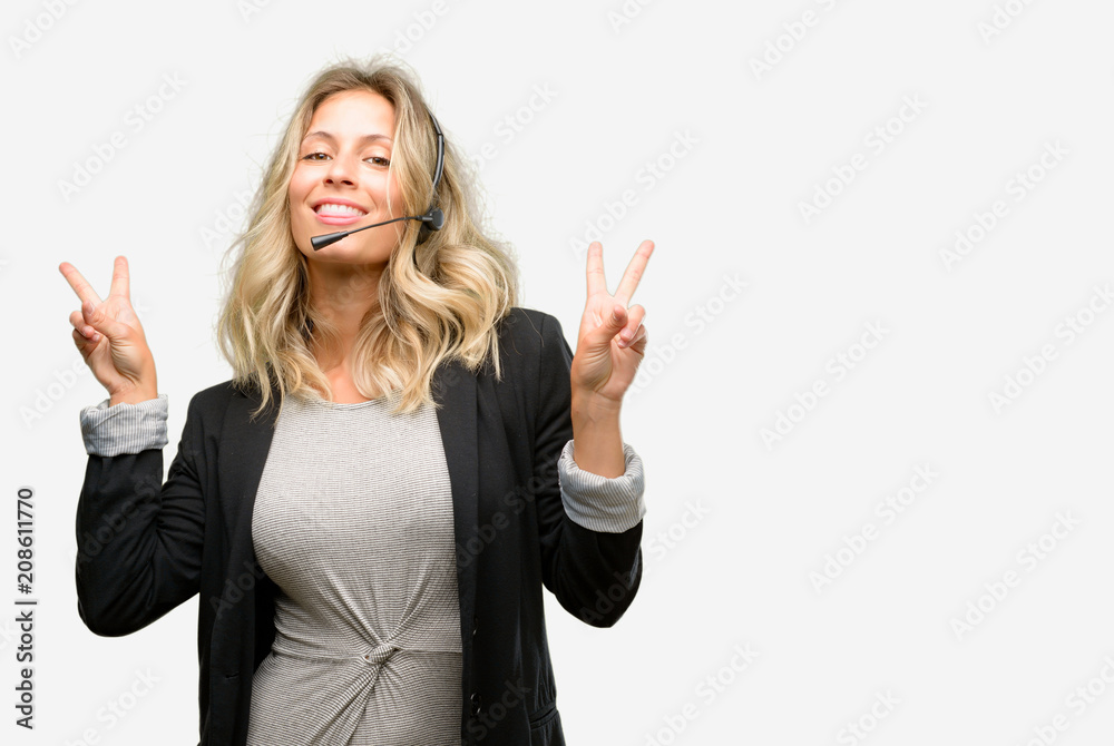 Young woman operator from call center looking at camera showing tong and making victory sign with fingers Young woman operator from call center looking at camera showing tong and making victory sign with fingers