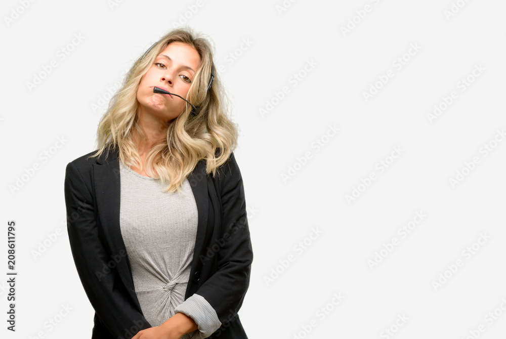 Young woman operator from call center with sleepy expression, being overworked and tired Young woman operator from call center with sleepy expression, being overworked and tired