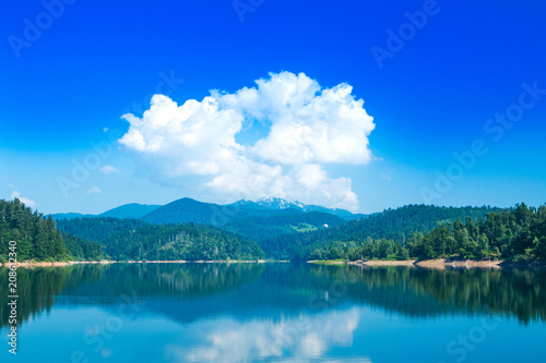Landscape of mountain area, Gorski kotar, beautiful Lokvarsko lake with Risnjak mountain in background, reflection in water 