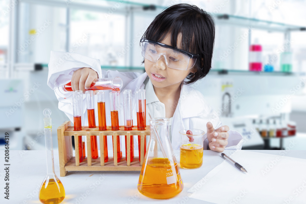 Clever school girl experimenting chemical liquid Clever school girl experimenting chemical liquid