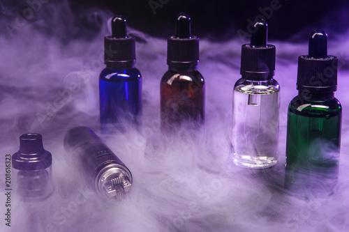 jars of liquids for vape in multi-colored smoke