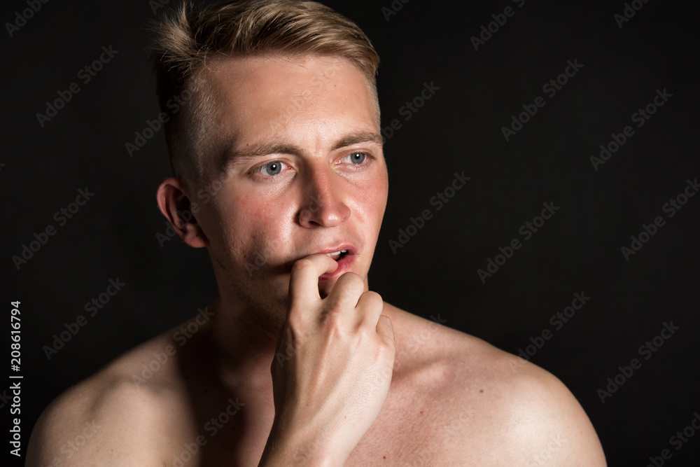 Curious attractive guy. Black background. 