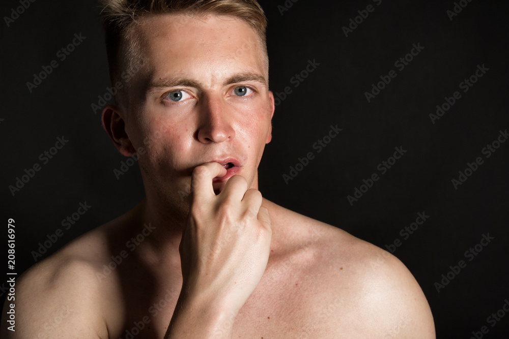 Curious attractive guy. Black background. 