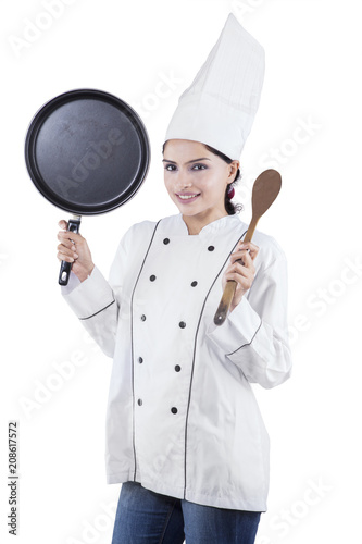 Female chef holding spatula and frying pan
