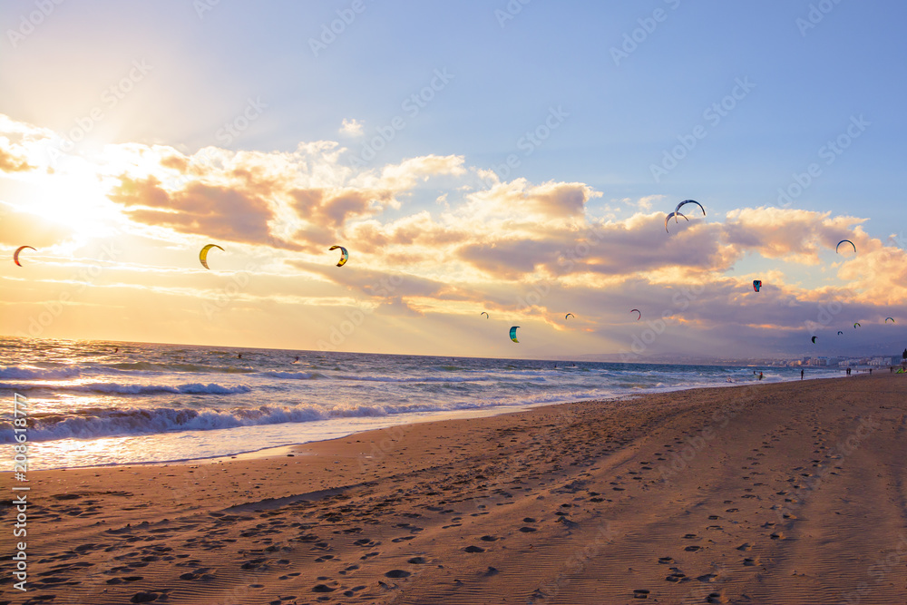 landscape of a beach in marbella with kite surfers in the ocean