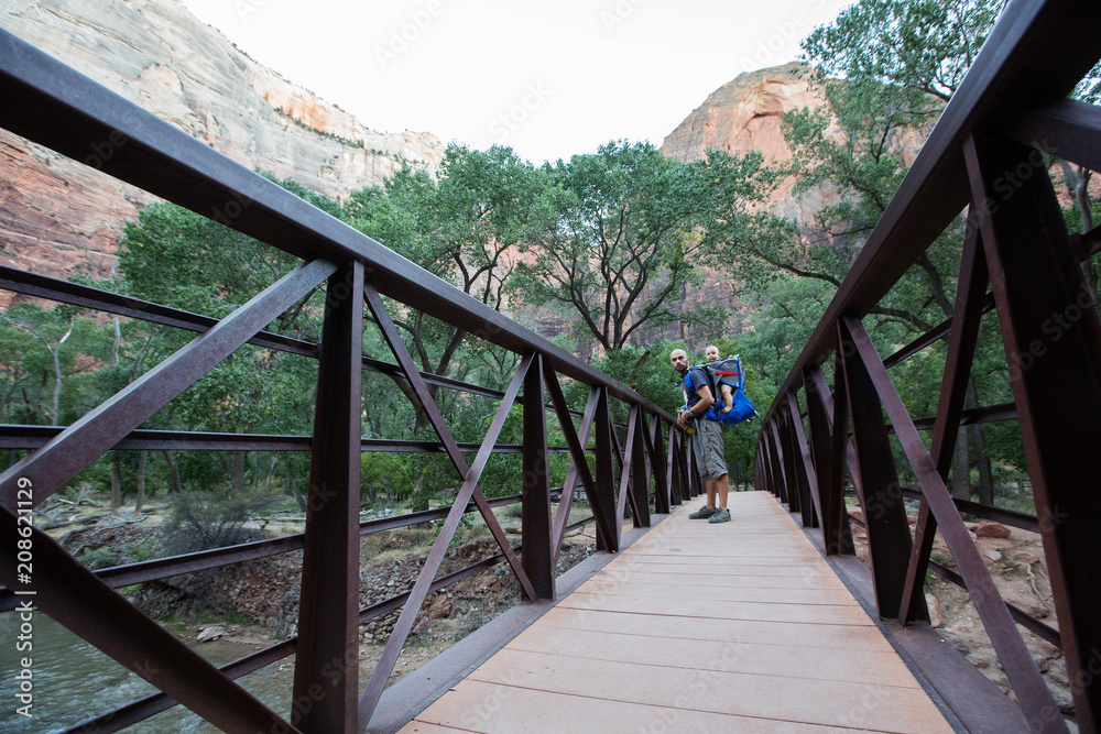 A man with his baby boy are trekking in Zion national park, Utah, USA