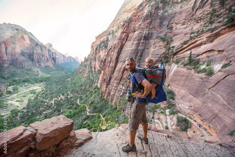 Obraz premium A man with his baby boy are trekking in Zion national park, Utah, USA