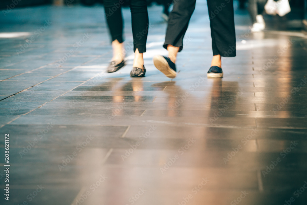 Blurred motion of people legs walking on pavement with copy space Blurred motion of people legs walking on pavement with copy space