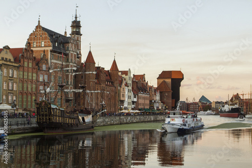 Ancient colored houses on the promenade of the river in Gdansk at sunset. Poland