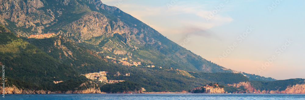 Adriatic sea coast with mountains in Montenegro, view on Sveti Stefan island at the sunset time, nature landscape