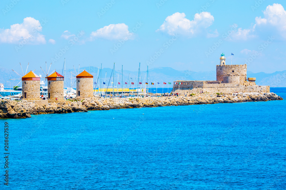 Historic windmills at Mandraki port and Fortress Agios Nikolaos in Rhodes Town, Mediterranean Sea, Rhodes Island, Greece