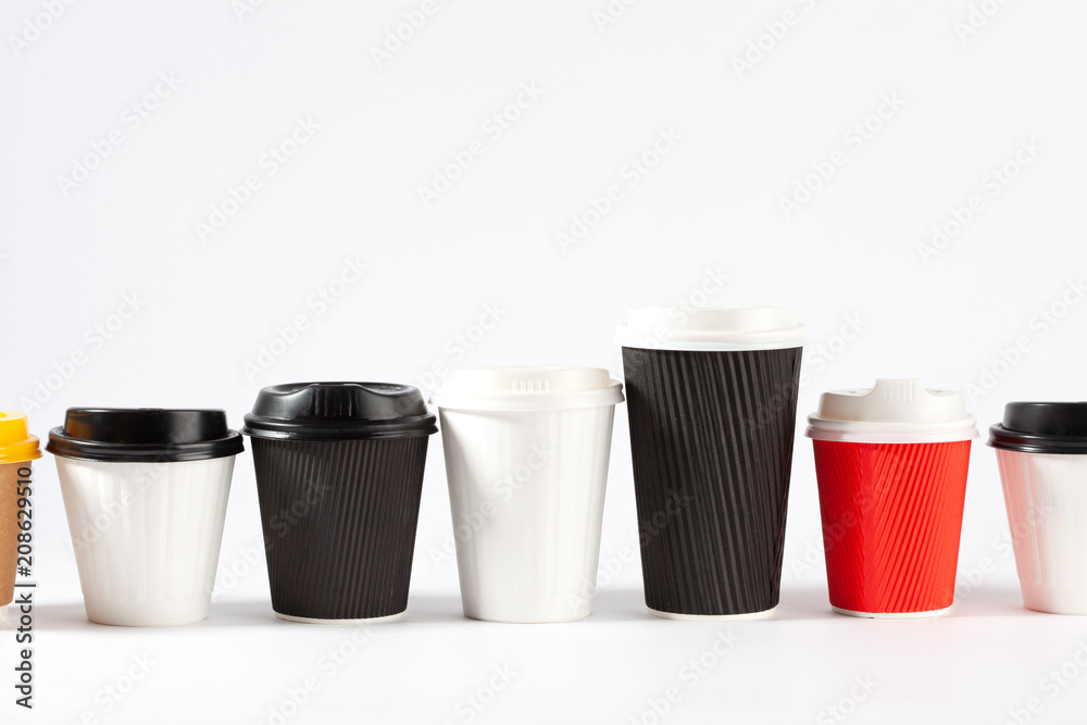 Endless row of disposable coffe cups of different colors and sizes on white background with copy space Endless row of disposable coffe cups of different colors and sizes on white background with copy space