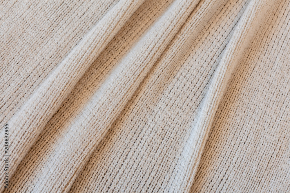 Soft beije fabric with folds background texture close-up Soft beije fabric with folds background texture close-up