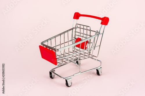Shopping trolley isolated on pink background.