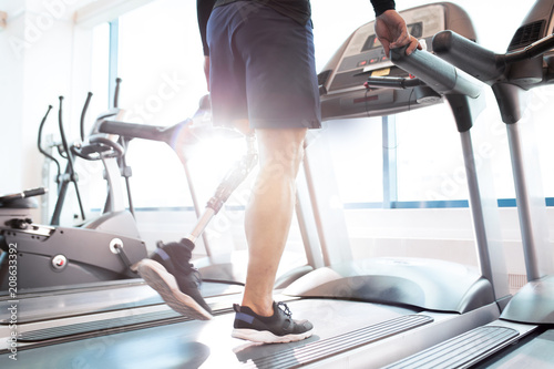 Close-up of disabled man walking on treadmill photo