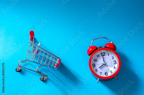 Time to shopping. Top View of shopping trolley on blue background with  copy space. photo