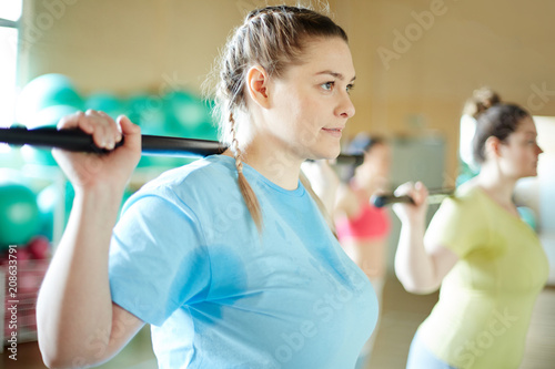 Cuadro en lienzo Young sweaty women with gymnastic bars doing exercises during workout