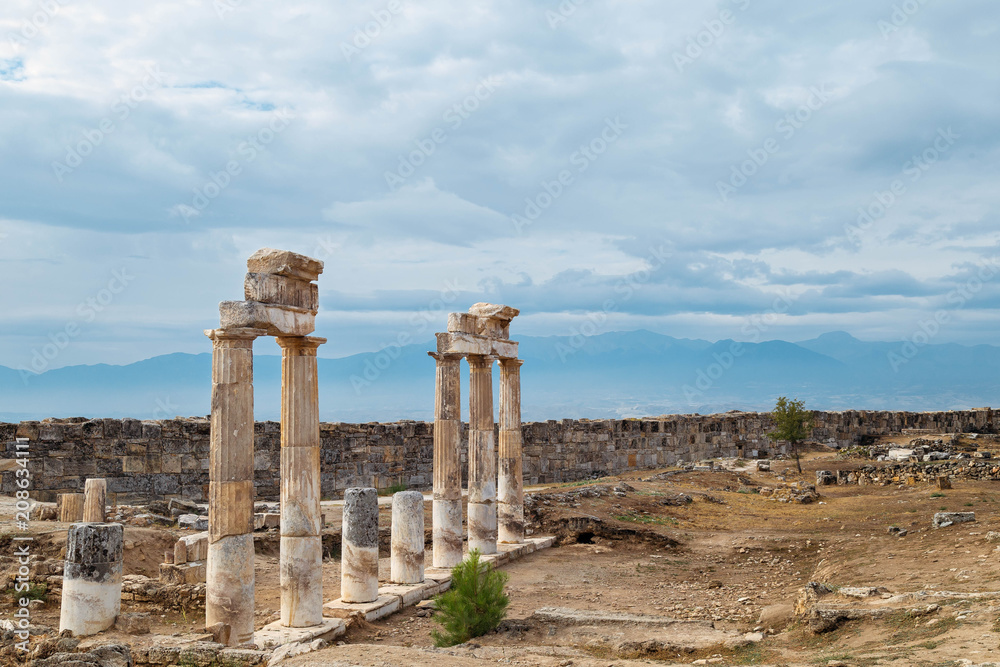 The ancient destroyed city of Hierapolis near Pamukkale, Denizli, Turkey in the summer. On a background the sky in overcast. Horizontal orientation