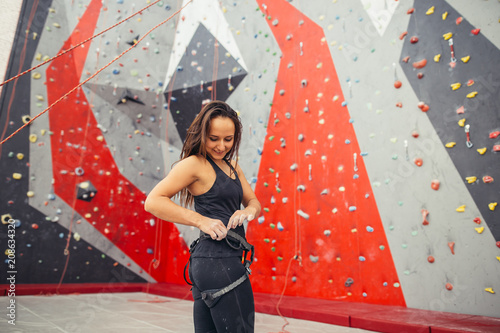 Athletic strong woman preparing for rope climbing exercise at the local gym. photo