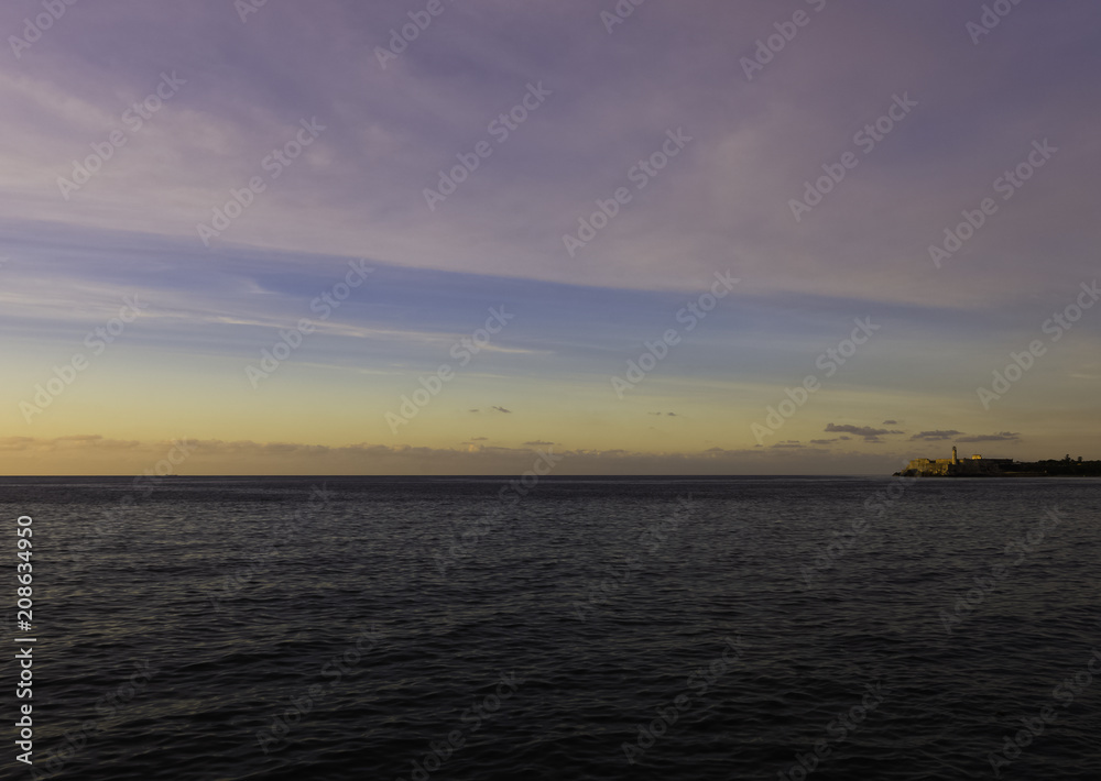 Sunset over Malecon and Atlantic Ocean with Morro Castle in background - Havana, Cuba 