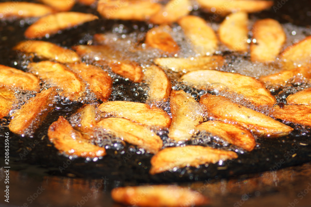 Sliced fries potato in boiling oil in frying pan wok