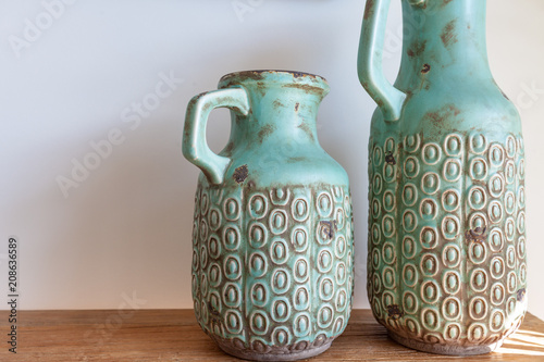 Принти на полотні Two decorative vases on wooden table against white wall close-up
