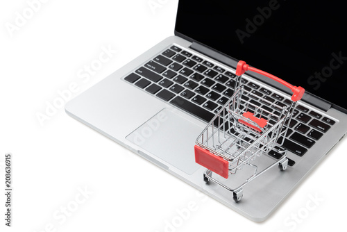 Shopping cart on a laptop keyboard isolated on white background, E-commerce, Shopping cart on laptop, Conceptual image, Ideas about online shopping