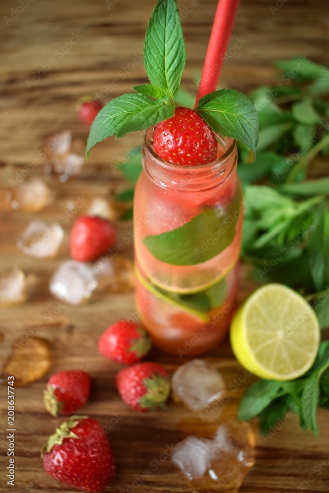 Lemonade with strawberry, lime, ice cubes and mint in a glass bottle Lemonade with strawberry, lime, ice cubes and mint in a glass bottle