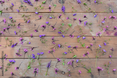 pink and purple wildflowers on an old wooden background with larch boards, top view